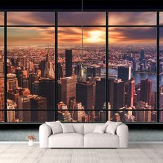 a living room with large windows and cityscape in the background at sunset or dawn