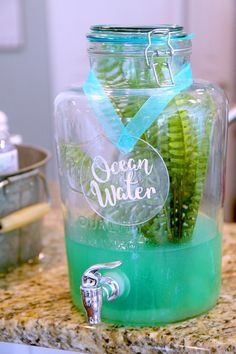 a glass jar filled with green liquid sitting on top of a counter