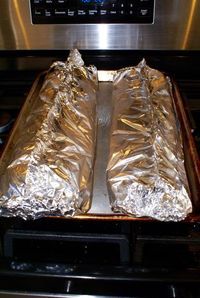 two pieces of foil sitting on top of an oven