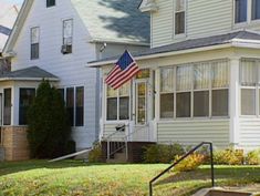 an american flag is on the front lawn of a house