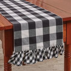 a black and white checkered table runner on top of a wooden dining room table