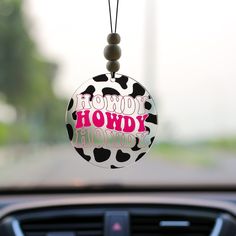 a car dashboard with a cow print key chain hanging from it's center console