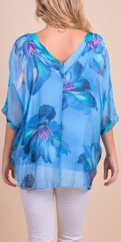 Floral Bloom Design on 100% Silk Blouse with Frayed Raw Edge Hemline. Soft, Stretchy Viscose Layer Underneath. 100% Silk Exterior | 95% Viscose | 5% Elastic Interior Made in Italy Fits Sizes XS- XL Model 5'7 Light Blue Printed V-neck Top, Blue Floral Print V-neck Blouse, Light Blue V-neck Blouse For Daywear, Blue V-neck Shirt For Spring, Light Blue V-neck Blouse With Floral Print, Blue V-neck Shirt For Daywear, Light Blue Floral Print V-neck Top, Printed Blue Tops, Printed Blue Tops For Daywear