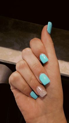 a woman's hand with blue and silver nail polish