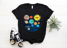 a t - shirt with an image of the solar system on it and some shoes