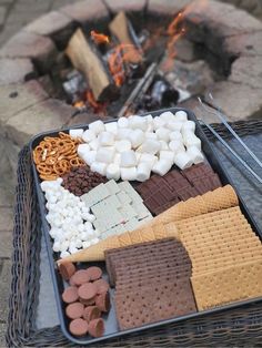 a basket filled with marshmallows, pretzels and crackers