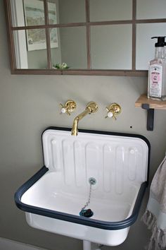 a white sink sitting under a bathroom mirror