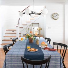 a dining room table is set with breakfast food and drinks on it, along with the stairs leading up to the second floor