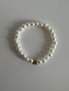 Pearl beaded bracelet, with a heart bead in the middle! :) Elegant Heart-shaped Beaded Bracelet, Elegant Heart-shaped 8mm Beads Bracelet, Elegant Heart-shaped Bracelets With 8mm Beads, Heart-shaped Beaded Pearl Bracelet Gift, Elegant Heart-shaped Beaded Friendship Bracelets, Elegant Beaded Heart-shaped Stretch Bracelet, White Pearl Bracelets With Heart Beads, Pearl Beaded Bracelets With Heart Beads, Adjustable Heart-shaped Pearl Bracelet With Heart Beads