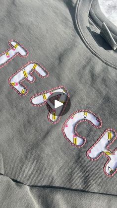 the back of a gray sweatshirt with embroidered letters on it