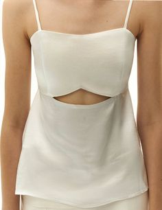 Enhance your style with our exquisite white open-back top, crafted to make a statement. This stunning piece showcases alluring front cut-out detail for a touch of contemporary flair. For a sophisticated ensemble, pair it with our satin finish long skirt, creating a chic suit-inspired look that exudes elegance. Embrace the fusion of modernity and grace with this impeccably coordinated set. Leave a lasting impression wherever you go with this fashion-forward combination. white color satin finish s Elegant Tie Back Top For Brunch, Chic White Dress With Cut-out Waist, White Backless Top For Evening, Chic Satin Backless Top, Elegant Sleeveless Cutout Top, Elegant Cut-out Waist Dress For Brunch, Elegant Dress With Cut-out Waist For Brunch, White Tie Back Top For Party, Elegant Summer Tops With Cutout Details