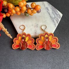 * These festive Thanksgiving Turkey earrings are crafted from brown and orange glitter acrylic, giving them a lively, shimmering appearance.  * Each earring is carefully hand-painted with acrylic paint to bring out the detailed design of the turkey. The back of the earrings is a solid orange, adding a bold, vibrant contrast. *  They are available with your choice of stainless steel metal or 14k gold-filled options for durability and style.  * You can further personalize the look by choosing from hooks, studs, or lever-back closures, making them a versatile accessory for the holiday season. * Perfect for Gifting, it comes in a jewelry box. * Ships in one business day, with a tracking number. * If you have any questions? please, don't hesitate to contact us. * For More Unique Handmade Jewelr Orange Earrings For Fall Season Gift, Fall Orange Earrings As Gift, Festive Orange Drop Earrings, Orange Drop Earrings For Festive Occasion, Brown Jewelry Gift For Fall, Brown Jewelry For Fall Season Gift, Brown Jewelry For Fall Gifts, Turkey Earrings, 3d Printing Art