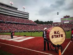 a marching band is performing on the field in front of an audience at a football game