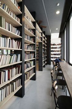 a long row of bookshelves filled with lots of books on top of wooden shelves