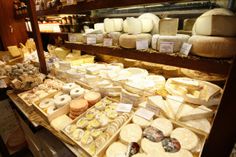 various types of cheese on display in a store