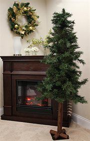 a small christmas tree in front of a fireplace with a wreath on the mantel