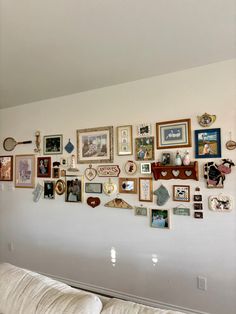 a living room wall filled with lots of framed pictures