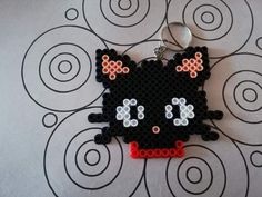 a black kitty keychain with white and red beads on it's face