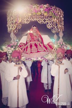 the bride and groom are posing in front of an elaborate carriage