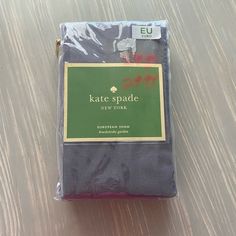 there is a packaged package for kate spade on the wooden table with it's label