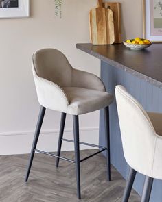 two white chairs sitting on top of a wooden counter