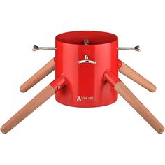 a red pot with wooden handles and four sticks sticking out of it's sides