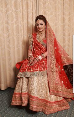 a woman in a red and gold bridal outfit