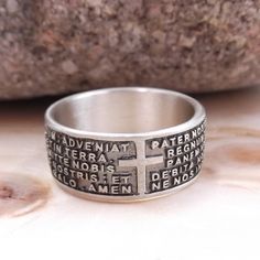 "Band ring with engraved prayer \"Our Father\" in Latin Features Material: silver Metal title: 925 Weight: gr. 7,50 Engraved prayer: Our Father in Latin Warranty: Gioielli Aurum Color: silver Subject: New Product code: aneb128_arg Various sizes available. Hypoallergenic - DOES NOT darken. The Jewel is new and is shipped insured by express courier, in gift box with warranty included. All our jewels are punched with the precious metals brand and the trademark. Watch the video of this ring at: http Symbolic Engraved Ring Stamped 925 For Promise, Sterling Silver Commemoration Rings, Sterling Silver Commemorative Round Rings, Silver Engraved Cross Ring, Spiritual White Gold Ring Stamped 925, Silver Hallmarked Rings For Commemoration, Engraved Silver Spiritual Rings, Symbolic Silver Ring For Commemoration, Symbolic Sterling Silver Cross Rings