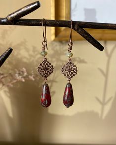 "Details & measurements: ~ Earthy deep red and swirling sea green Czech glass teardrop beads with Picasso finish (20 x 10mm) dangle from beautifully detailed, dainty antique copper filigree charms (13 x 17mm)  ~ Accented with Czech glass rondelle beads in light green w/ rustic Picasso finish (3 x 5mm) ~ They hang from antique copper ear wires ~ Earrings hang almost 2 3/4\" long ♡ Packaged safely & sustainably in a kraft box with cotton ribbon & dried organic florals. This makes for a beautiful gift, or something pretty for yourself! All packaging materials are zero waste and also reusable. ♡ As well, we always aim to ship with plastic-free packing materials. Sustainability is an integral part of our lives, and we bring that same dedication to our small business." Rustic Light, Cotton Ribbon, Teardrop Beads, Bohemian Earrings, Green Accents, Wire Earrings, Copper Earrings, Sea Green, Copper Jewelry