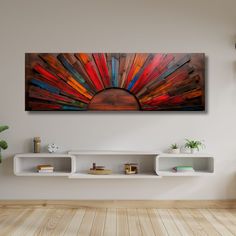 a painting hanging on the wall in a room with wooden flooring and white shelves