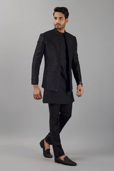 Black raw silk jodhpuri jacket with pintucks. Comes with pant and a kurta.
Components: 3
Pattern: Pintucked
Neckline: Mandarin Neck
Sleeve Type: Full
Fabric: Raw silk
Color: Black
Other Details: 
Closure : Kurta - Side zip
Occasion: Sangeet - Aza Fashions Designer Tailored Kurta For Festive Occasions, Fitted Cotton Silk Bandhgala With Cutdana, Fitted Cotton Silk Bandhgala With Long Sleeves, Designer Black Kurta With Naqshi, Eid Cotton Silk Fitted Bandhgala, Eid Fitted Cotton Silk Bandhgala, Fitted Cotton Silk Bandhgala For Eid, Tailored Nehru Jacket For Festive Designer Wear, Tailored Kurta For Festive Occasions