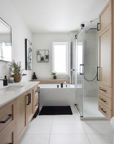 a white bathroom with wooden cabinets and a bathtub