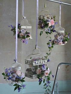 three birdcages with flowers hanging from them