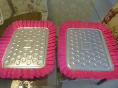 two metal pans sitting next to each other on top of pink paper plates with holes in them