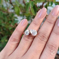 a woman's hand with two engagement rings on it