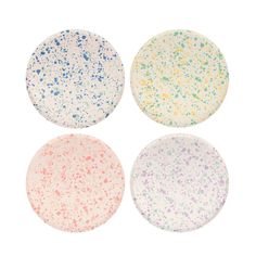 four different colored plates with splatkles on the top, one is white and one