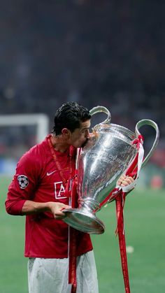 a soccer player kissing the trophy on the field