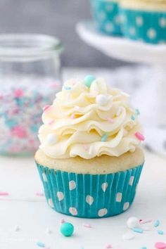 a cupcake with white frosting and sprinkles