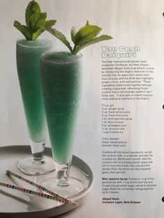 two glasses filled with green liquid on top of a plate