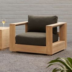 a wooden chair and side table with a glass of wine on the floor next to it