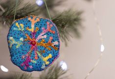 a blue ornament hanging from a christmas tree