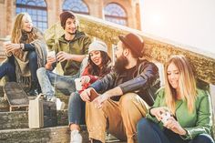 group of young people sitting on steps with their skateboards and drinking tea or coffee