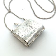 "Miniature Purse Sterling Silver Necklace- Vintage Stamp Holder 28\" Length Necklace- ET1168 This miniature purse necklace opens and closes securely and was originally intended as a stamp holder! It has been beautifully hand -engraved.  It hangs on a 28\" sterling silver rope chain with an additional 1.5\" length that is meant to resemble a shoulder strap. Metal Content: Sterling Silver Measurements Length of purse:  1 5/16\"  (33mm) Width:  1 1/8\" (29mm) Chain;  - Sterling Silver Rope Chain 28\" in length. No clasp - 3\" of sterling silver cable chain attached to the purse itself Weight: 14.6 Grams Stamps: 925 AN Condition: Excellent Pre-Owned Each piece is thoroughly examined and refinished as needed by our professional jewelers, tested to guarantee metal content,  graded by our in-hous Purse Necklace, Miniature Purse, Silver Rope Chain, Metallic Purse, Length Necklace, Silver Jewels, Vintage Stamps, Sterling Silver Necklace Pendants, Mini Purse