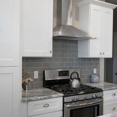 a stove top oven sitting inside of a kitchen next to white cabinets and counter tops