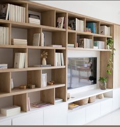 a living room with bookshelves and a television on top of the entertainment center