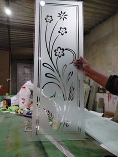 a man is working on an etched glass panel