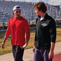 two men standing next to each other on a field