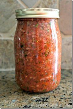 a jar filled with red sauce sitting on top of a counter