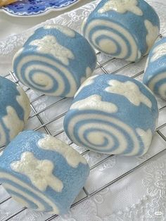 four blue and white swirled donuts sitting on a cooling rack next to a plate