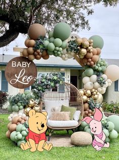 winnie the pooh balloon arch with balloons and decorations for baby's first birthday